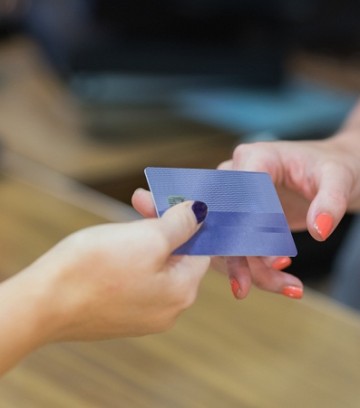 Woman handing over credit card at cash register